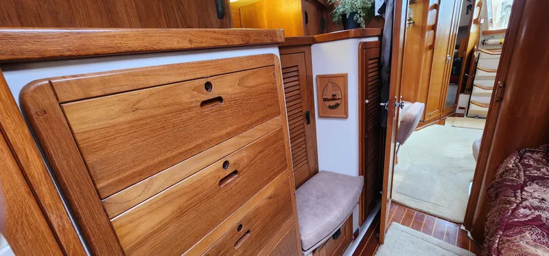 Interior of a 1995 Catalina 42 MkII sailboat with wooden cabinetry and cozy seating.