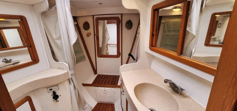 Interior of 1995 Catalina 42 MkII sailboat bathroom with sink and wooden accents.