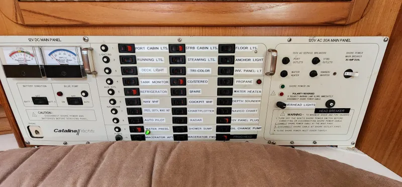 Electrical control panel of a 1995 Catalina 42 MkII sailboat, featuring various switches and gauges.