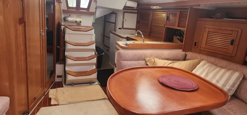 Interior of 1995 Catalina 42 MkII sailboat with wooden furnishings and cozy seating area.