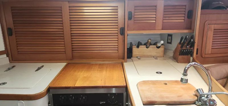 Galley kitchen in 1995 Catalina 42 MkII sailboat with wooden cabinets and countertop.