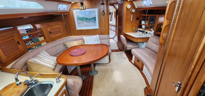 Interior of 1995 Catalina 42 MkII sailboat with cozy seating and wooden finishes.