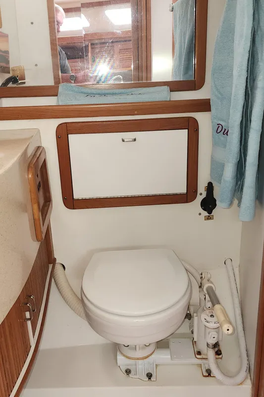 1995 Catalina 42 MkII yacht bathroom with toilet, wooden accents, and mirror.