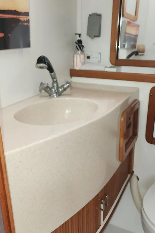 1995 Catalina 42 MkII yacht bathroom with sink, faucet, and mirror.