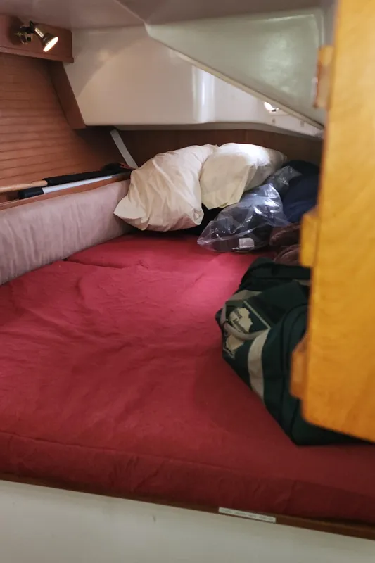 Cozy cabin interior of 1995 Catalina 42 MkII sailboat with red bedding and storage.