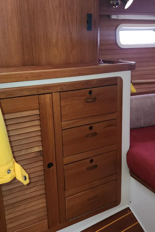 Wooden interior of a 1995 Catalina 42 MkII sailboat with storage cabinets and seating.