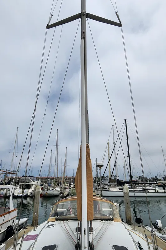 1995 Catalina 42 MkII sailboat docked in a marina, surrounded by other boats.