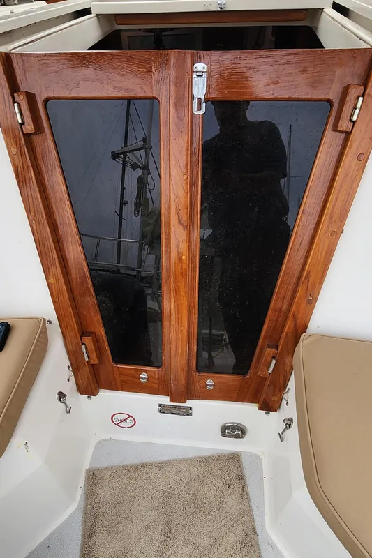 1995 Catalina 42 MkII sailboat cabin entrance with wooden doors and cushioned seating.
