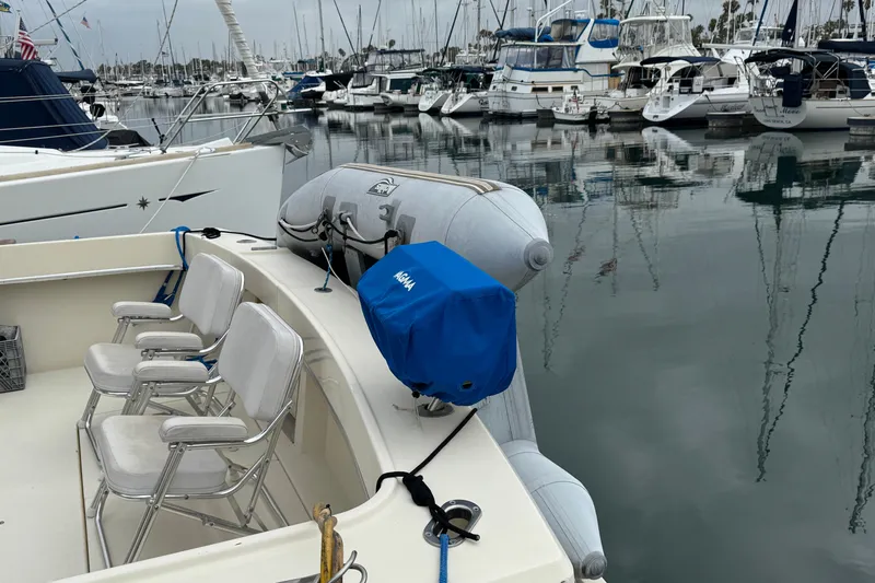 1983 Hatteras 36 Convertible yacht docked in marina with inflatable dinghy.