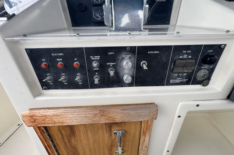 Control panel of a 1983 Hatteras 36 Convertible boat with switches and gauges.