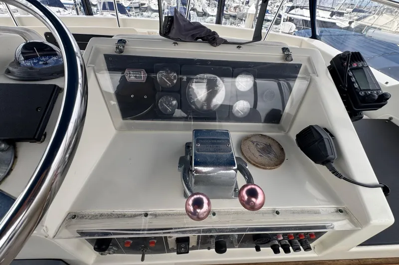 Control panel of a 1983 Hatteras 36 Convertible boat with gauges and throttle levers.