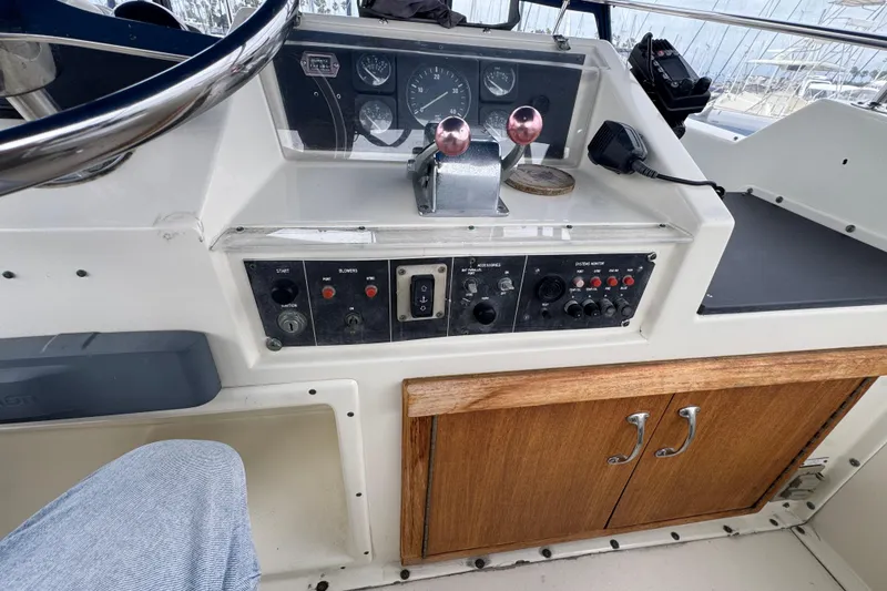 Control panel of a 1983 Hatteras 36 Convertible boat with steering wheel and gauges.