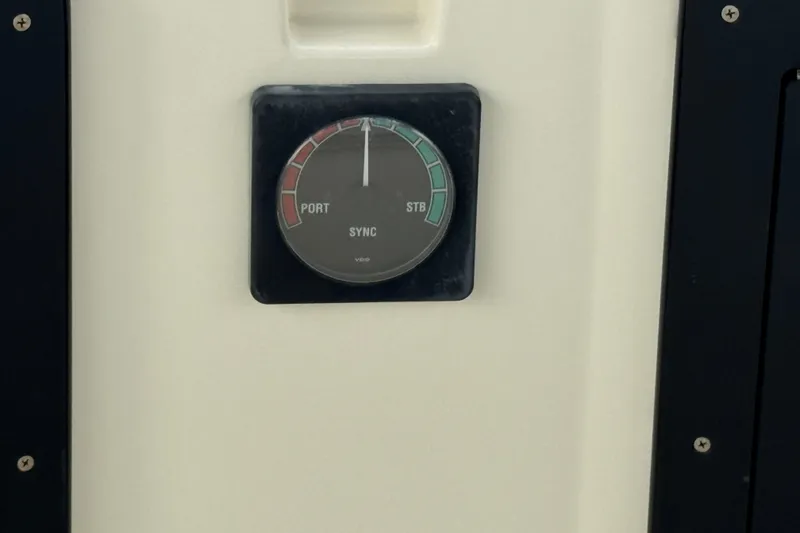 Gauge on 1983 Hatteras 36 Convertible boat dashboard, displaying port and starboard synchronization.