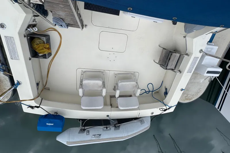 1983 Hatteras 36 Convertible boat deck with chairs and equipment, docked by the water.