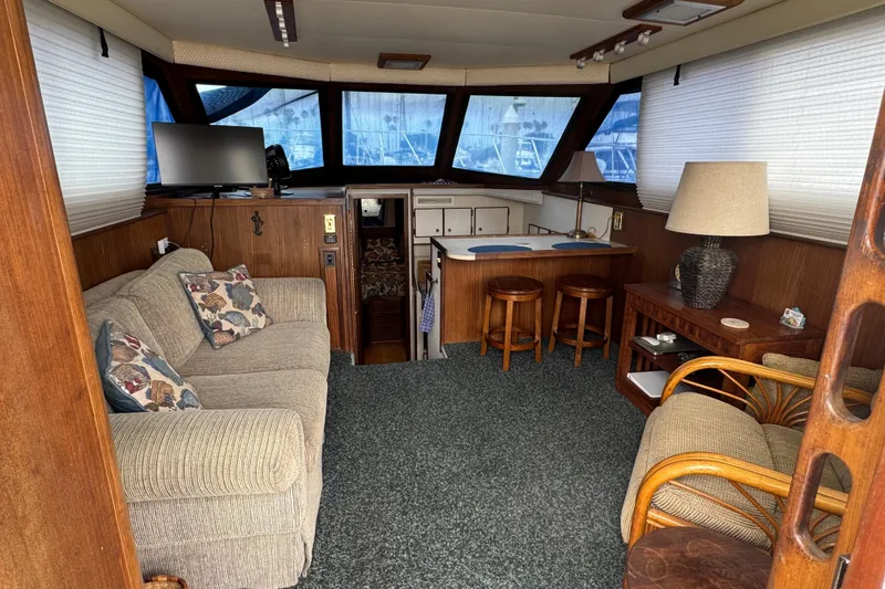 Interior of a 1983 Hatteras 36 Convertible yacht with cozy seating and nautical decor.