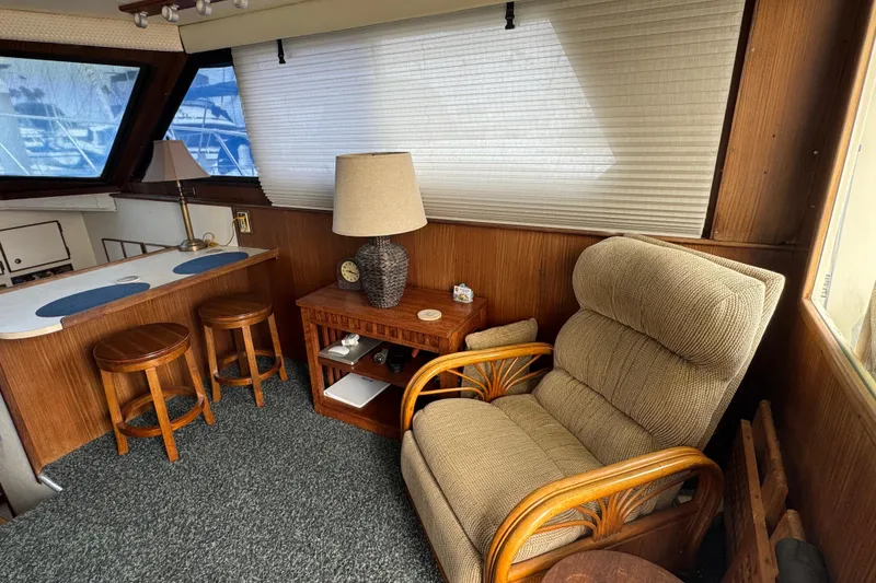 Interior of 1983 Hatteras 36 Convertible yacht with cozy seating and wooden decor.