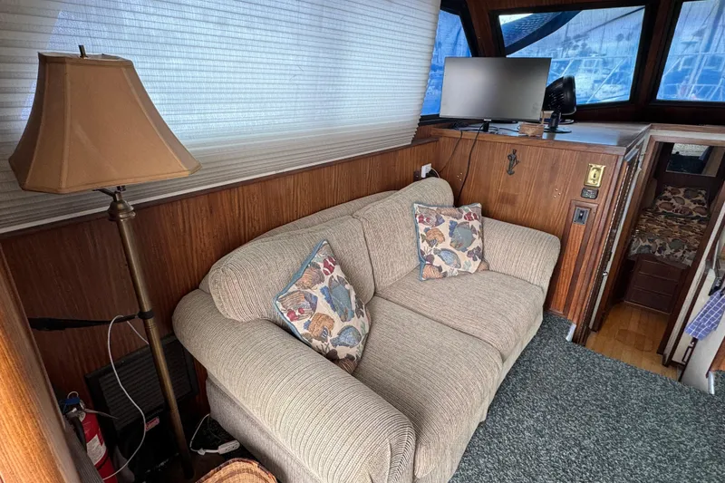 Cozy interior of 1983 Hatteras 36 Convertible with sofa, lamp, and TV.