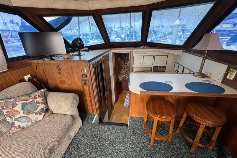 Interior of 1983 Hatteras 36 Convertible yacht with cozy seating and nautical decor.