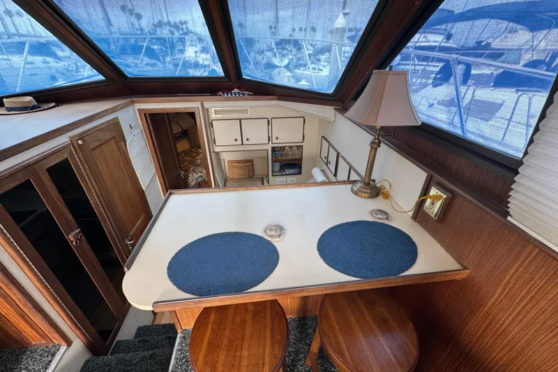 Interior of 1983 Hatteras 36 Convertible yacht with wooden cabinetry and seating area.