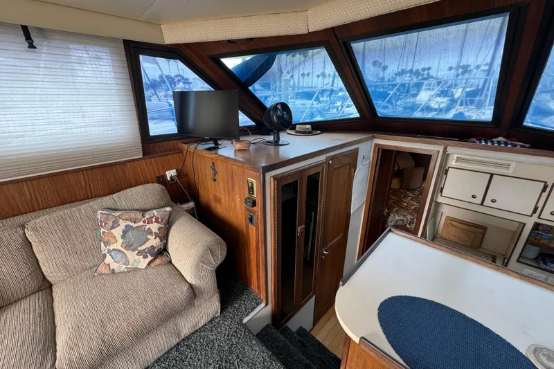 Interior of 1983 Hatteras 36 Convertible yacht with cozy seating and nautical decor.