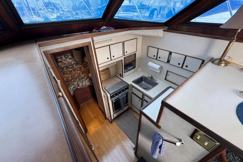 Interior of 1983 Hatteras 36 Convertible yacht with compact kitchen and cozy cabin.