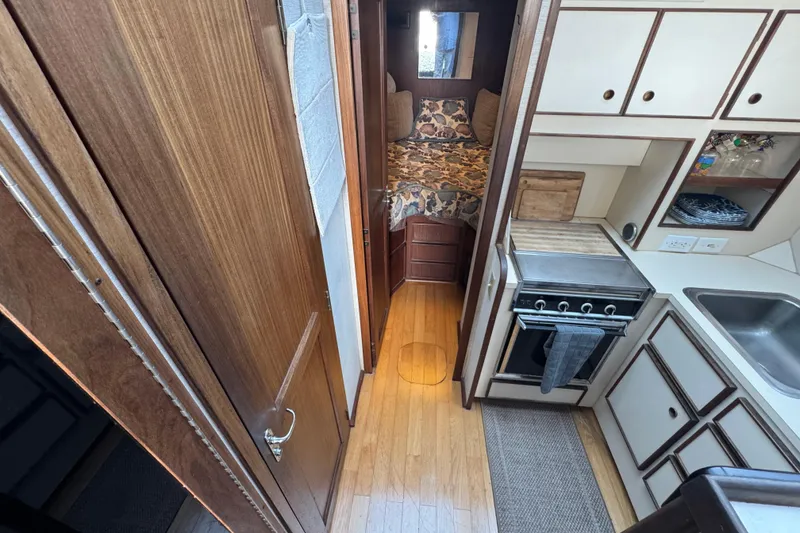 Interior of 1983 Hatteras 36 Convertible yacht with kitchen and cozy sleeping area.