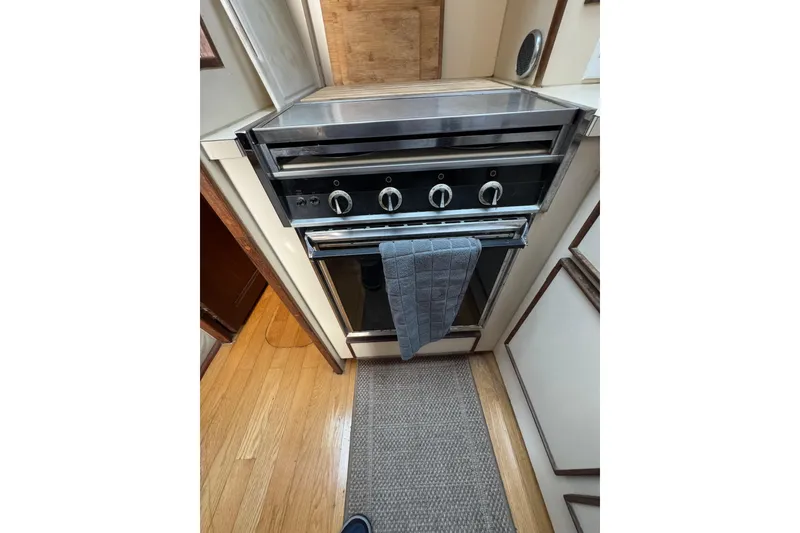 1983 Hatteras 36 Convertible yacht kitchen with stainless steel oven and wooden flooring.