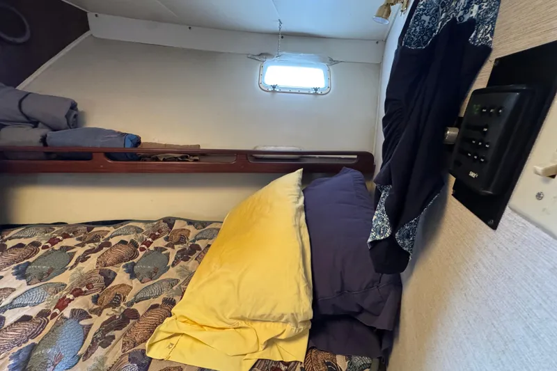Cozy cabin interior of 1983 Hatteras 36 Convertible with fish-patterned bedding.