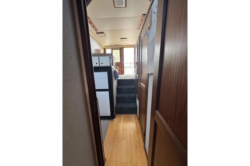 Interior hallway of 1983 Hatteras 36 Convertible yacht with wood paneling and compact kitchen.