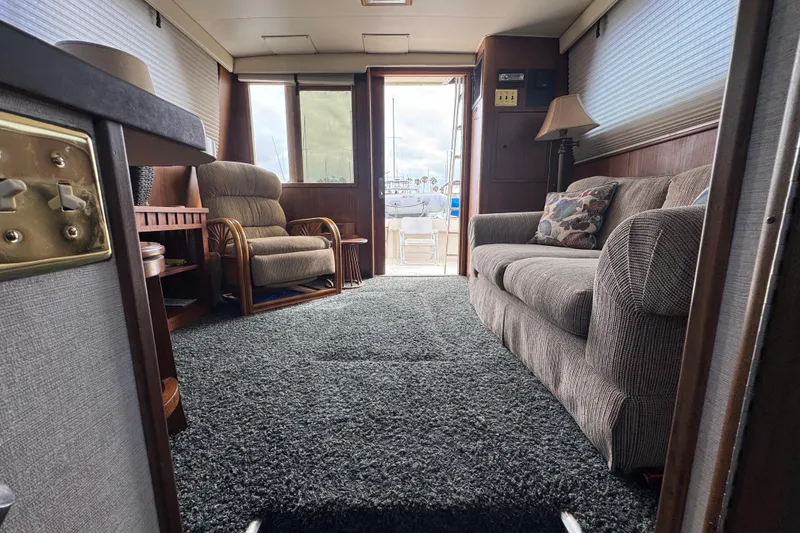 Interior of 1983 Hatteras 36 Convertible yacht with cozy seating and carpeted floor.