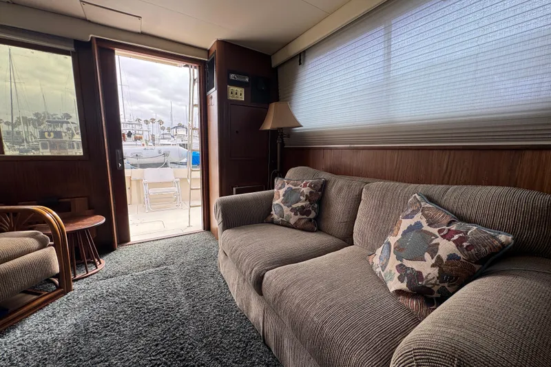 Interior of 1983 Hatteras 36 Convertible yacht with cozy seating and marina view.