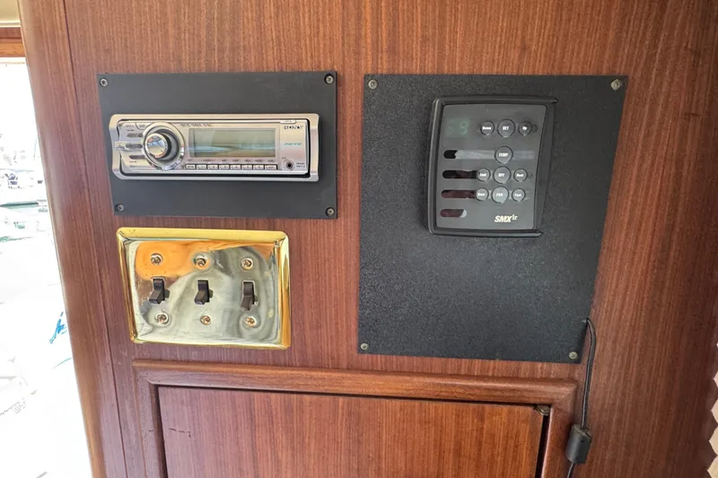 Control panel on 1983 Hatteras 36 Convertible yacht with radio and switches.