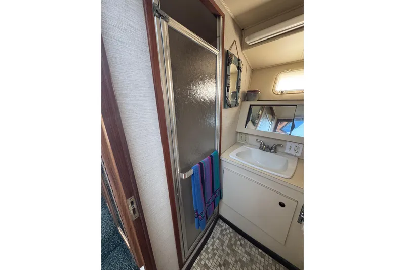 Bathroom interior of 1983 Hatteras 36 Convertible yacht with shower and sink.