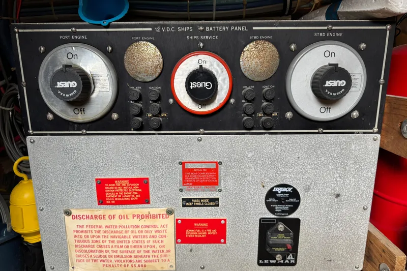 Control panel of a 1983 Hatteras 36 Convertible boat with warning labels.