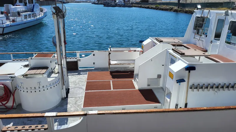 1958 Ditmar & Donaldson sport boat deck with wooden flooring, docked by the water.