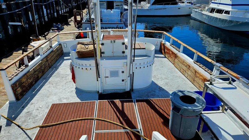 1958 Ditmar & Donaldson sport boat docked, featuring wooden deck and marina backdrop.