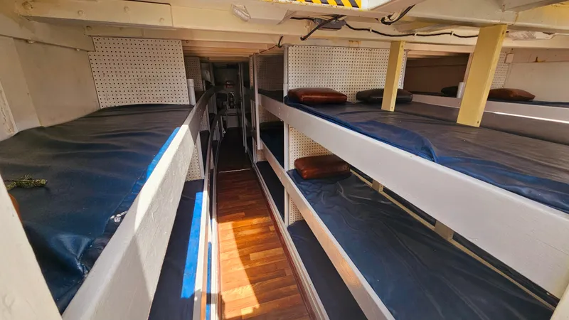 1958 Ditmar & Donaldson Sport Boat interior with multiple bunk beds and wooden flooring.