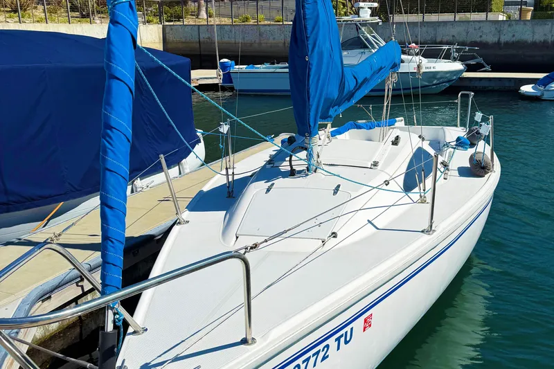 2002 Catalina 22 Capri sailboat docked in marina with blue covers.