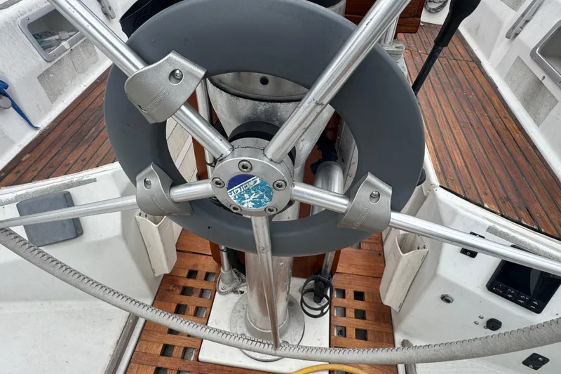 Steering wheel of 1985 Beneteau First 38 sailboat with wooden deck details.