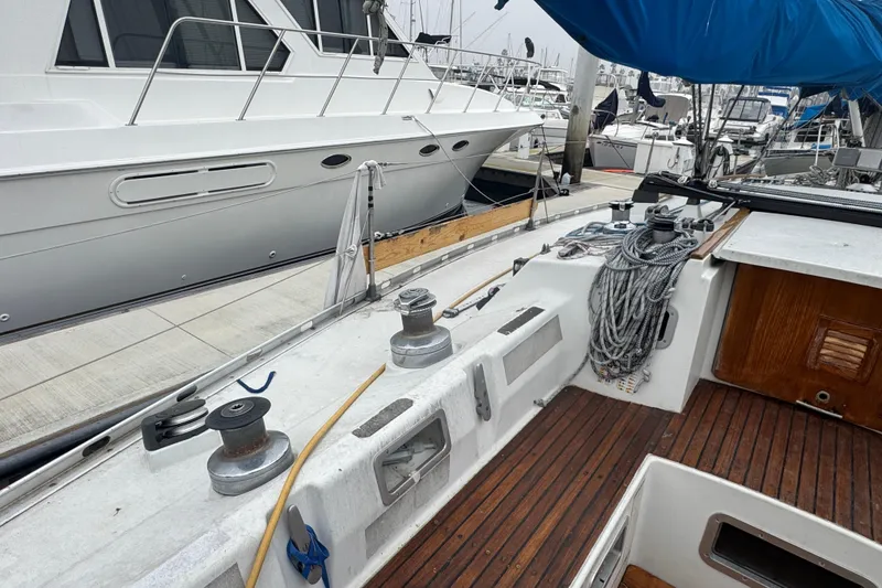 Cockpit view of a 1985 Beneteau First 38 sailboat docked at a marina.