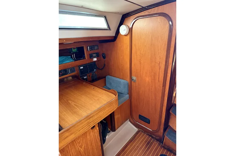 Interior of 1985 Beneteau First 38 sailboat with wooden finish and navigation equipment.