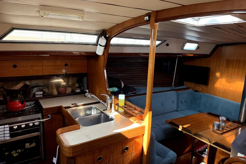 Interior of 1985 Beneteau First 38 sailboat with kitchen and seating area.