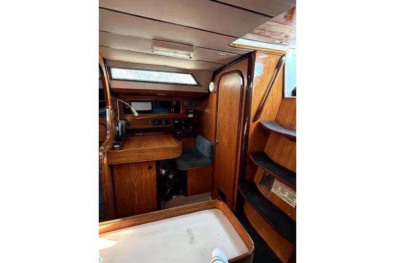 Interior of 1985 Beneteau First 38 sailboat with wooden cabinetry and seating area.