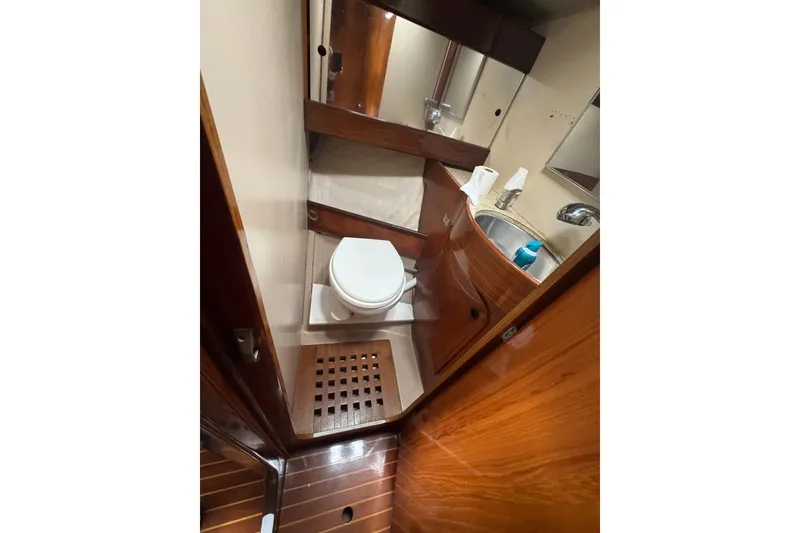 1985 Beneteau First 38 yacht bathroom with wooden cabinetry and compact design.
