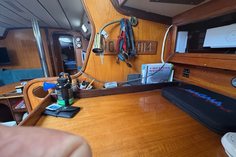 Interior of a 1985 Beneteau First 38 sailboat with wooden finish and nautical equipment.