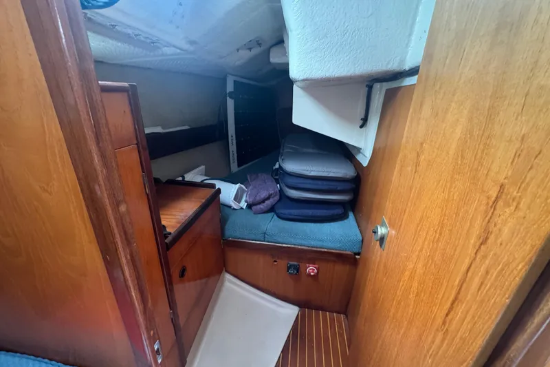 1985 Beneteau First 38 cabin interior with wooden finish and storage area.