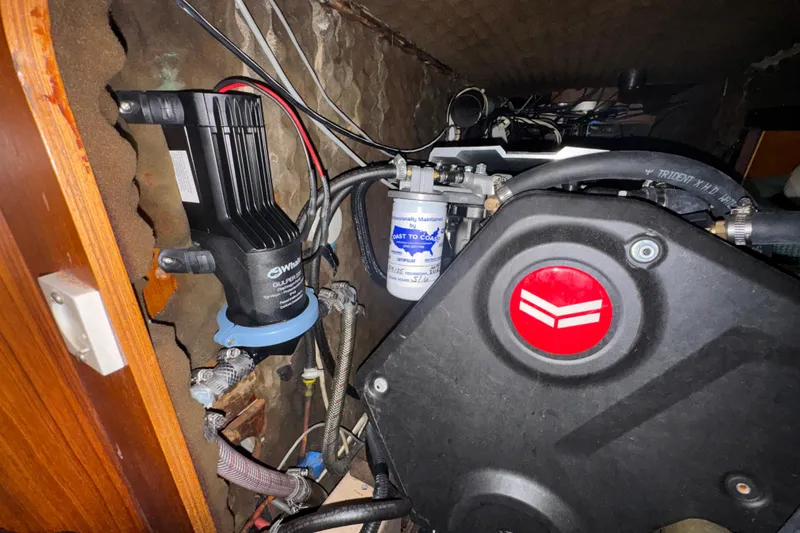 Engine compartment of a 1985 Beneteau First 38 sailboat, featuring mechanical components and wiring.