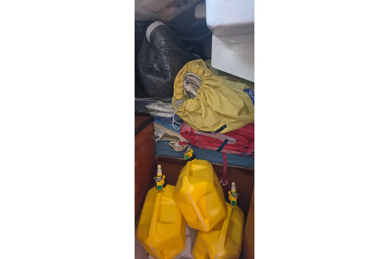 Storage area in a 1985 Beneteau First 38 sailboat with yellow fuel containers.