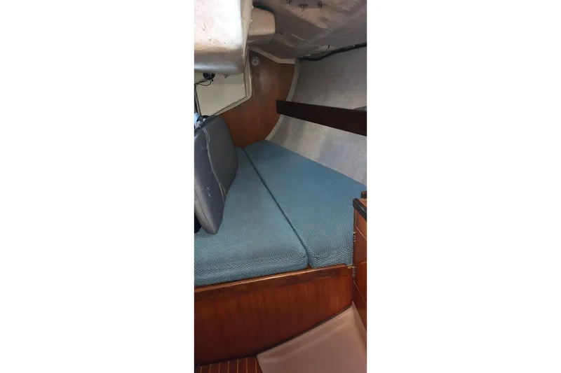 Interior cabin of 1985 Beneteau First 38 sailboat with blue cushions.
