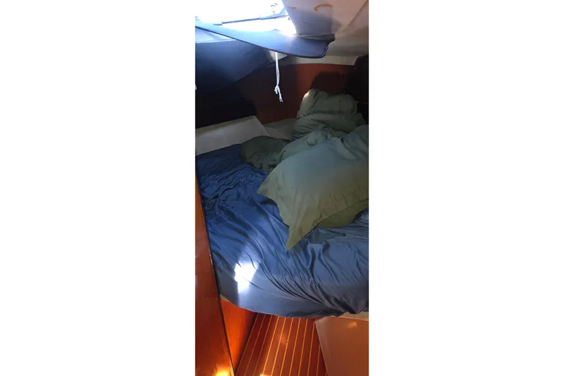 Cozy cabin interior of 1985 Beneteau First 38 sailboat with blue bedding.